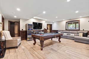 Recreation room featuring a wainscoted wall, billiards table, wine cooler, light wood-style floors, and recessed lighting
