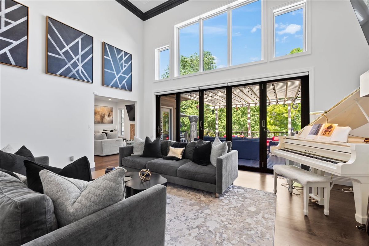 Living room with wood finished floors, crown molding, a high ceiling, and french doors