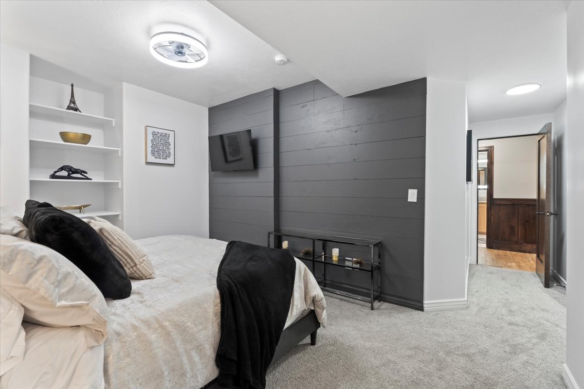 Bedroom with wood walls, carpet floors, and an accent wall