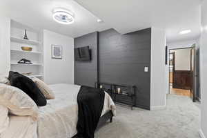 Bedroom with wood walls, carpet floors, and an accent wall