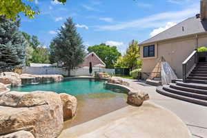 View of swimming pool featuring patio surround and a fenced backyard