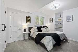 Bedroom with baseboards and light carpet