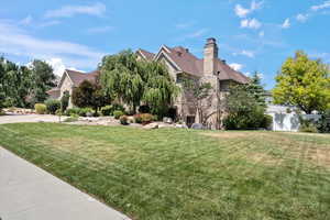 View of side of property featuring a yard and a chimney