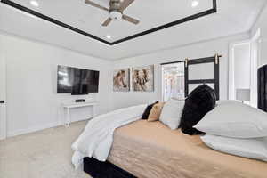 Carpeted bedroom featuring a barn door, a raised ceiling, recessed lighting, and ceiling fan