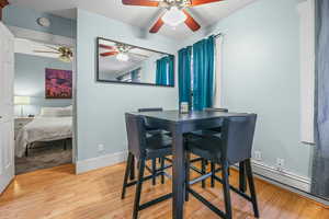 Dining area with light wood finished floors and ceiling fan