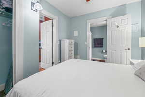 Bedroom featuring ensuite bath and ceiling fan