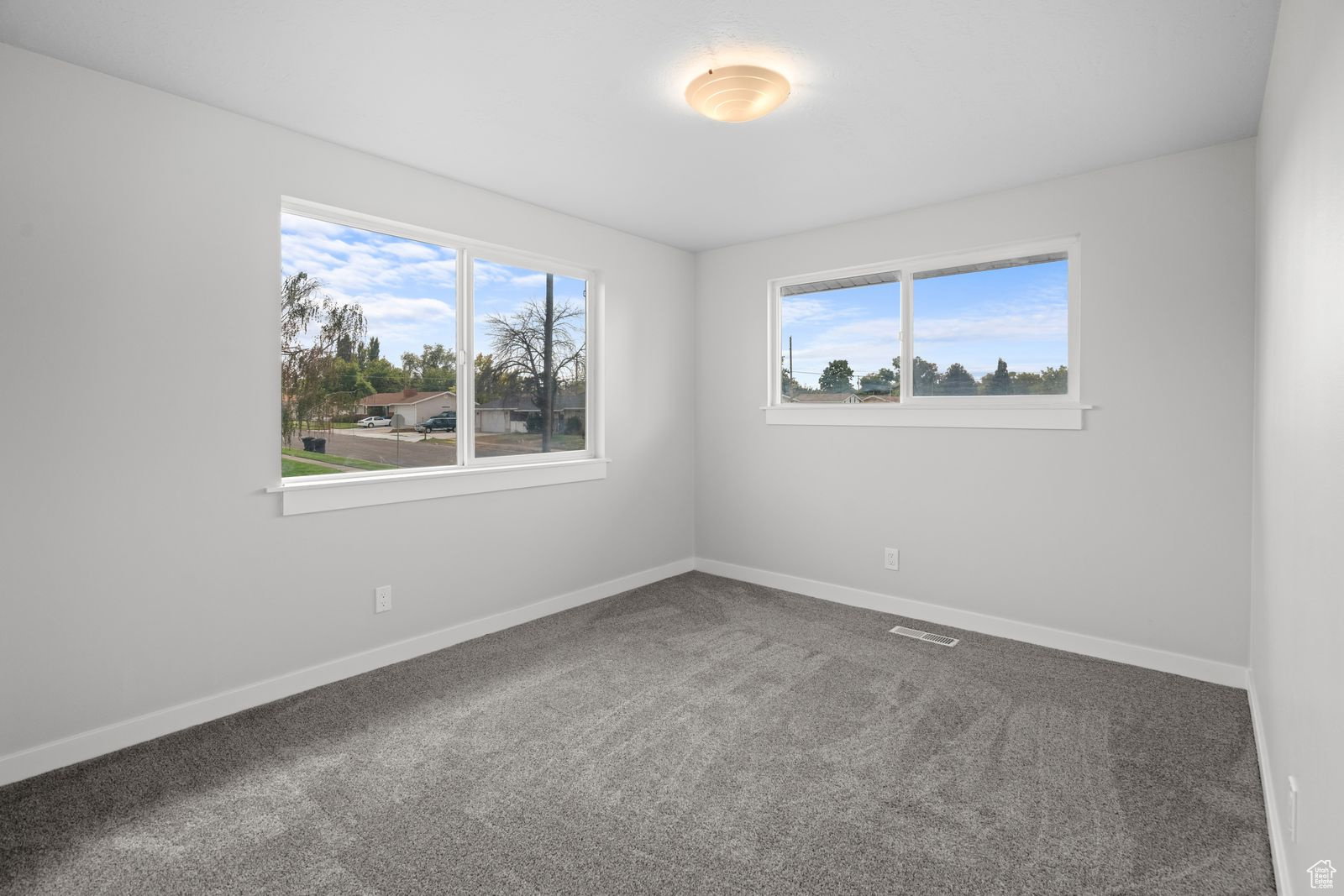 Empty room featuring carpet floors and healthy amount of natural light