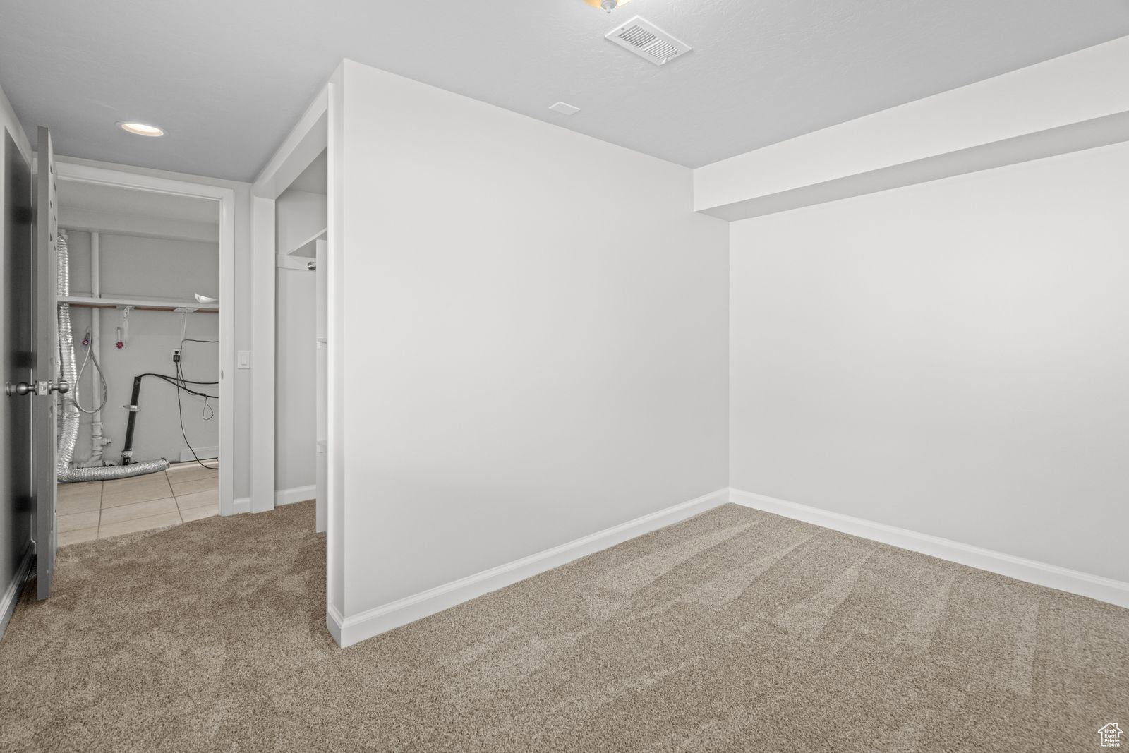 Hall with light carpet and recessed lighting