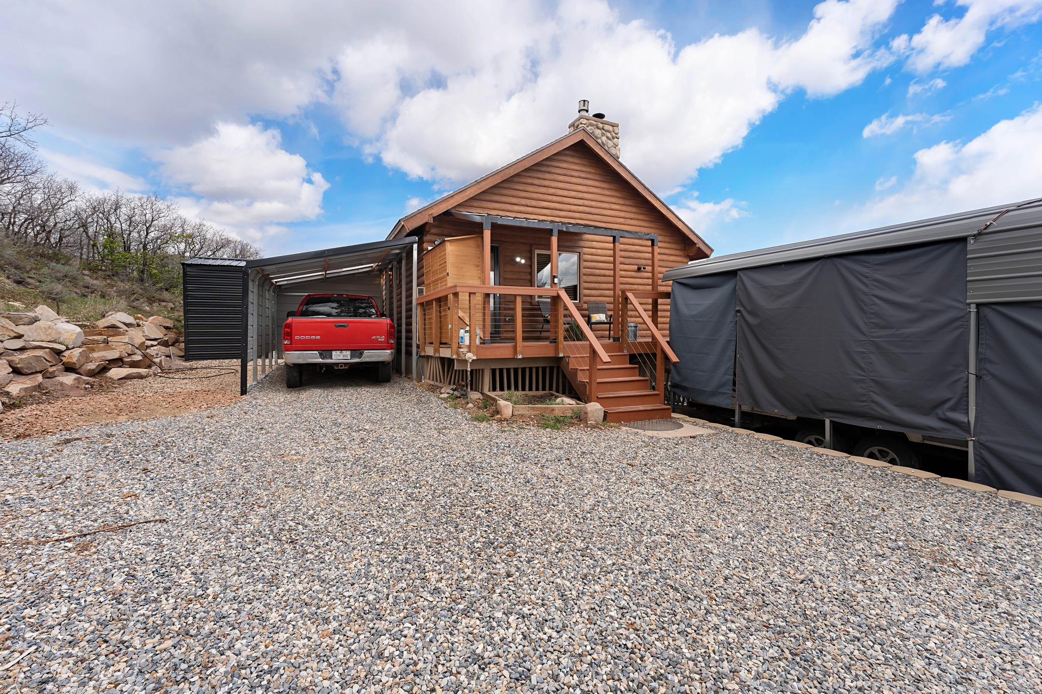 View of outdoor structure with gravel driveway and a carport