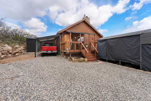 View of outdoor structure with gravel driveway and a carport