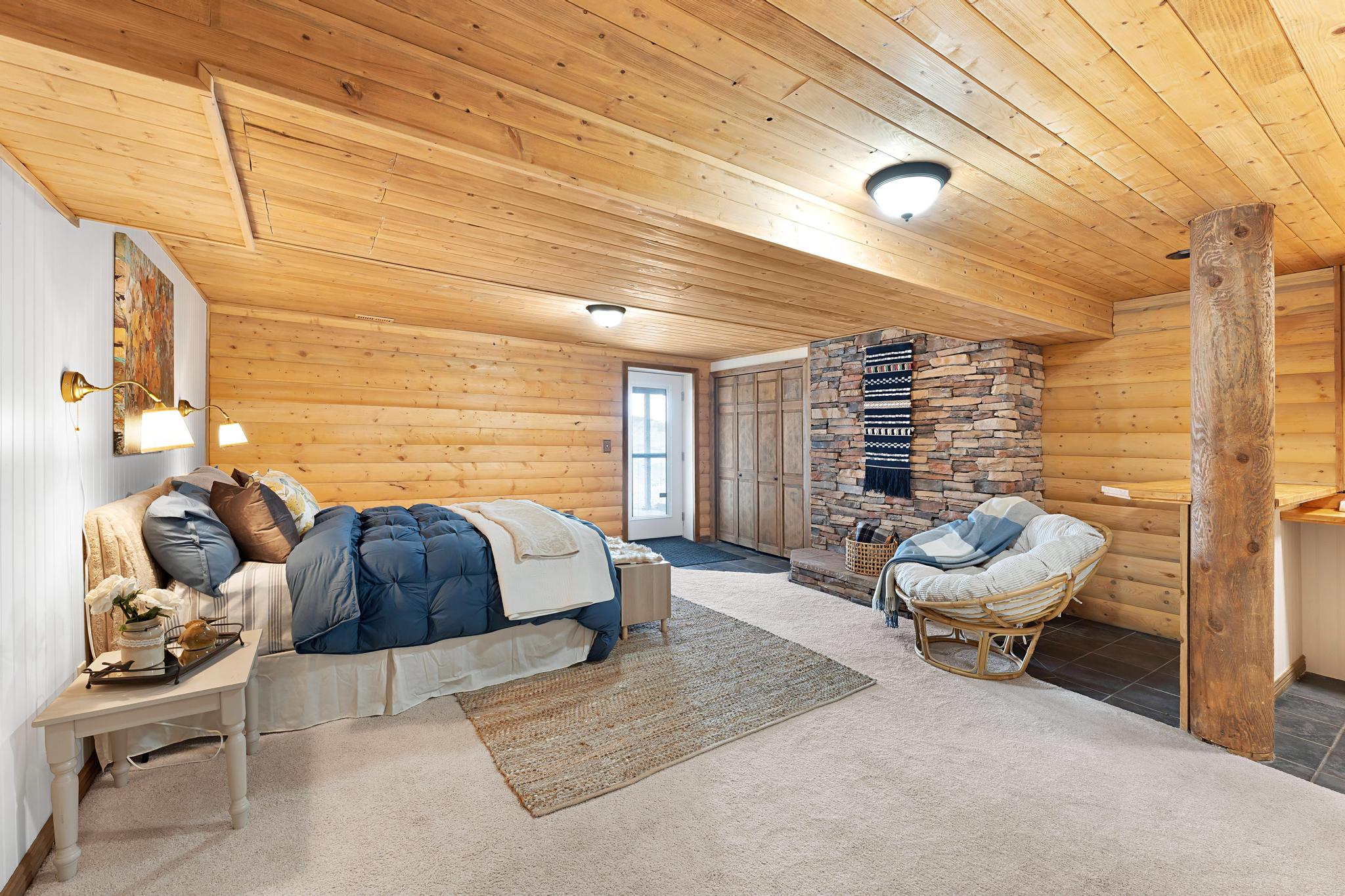 Bedroom featuring log walls, carpet, and wood ceiling