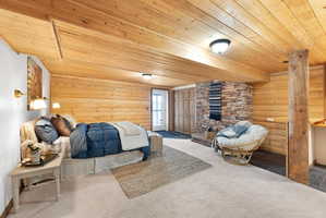 Bedroom featuring log walls, carpet, and wood ceiling
