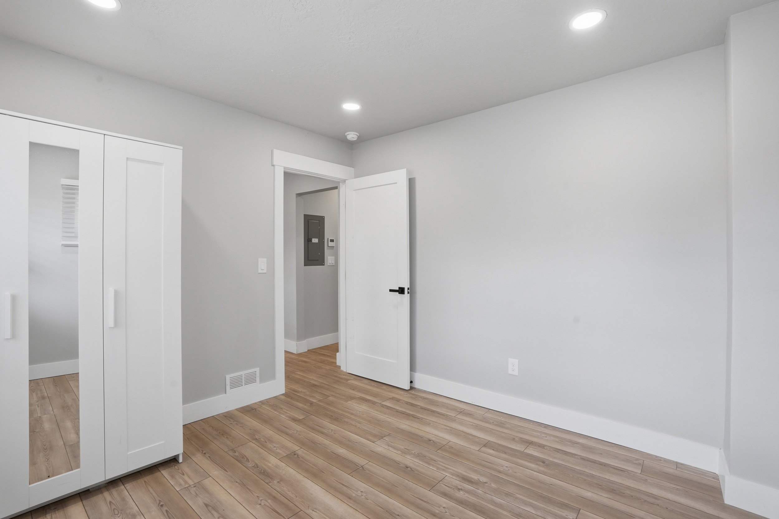 Unit #40 Unfurnished bedroom with light wood finished floors, recessed lighting, a closet, and electric panel