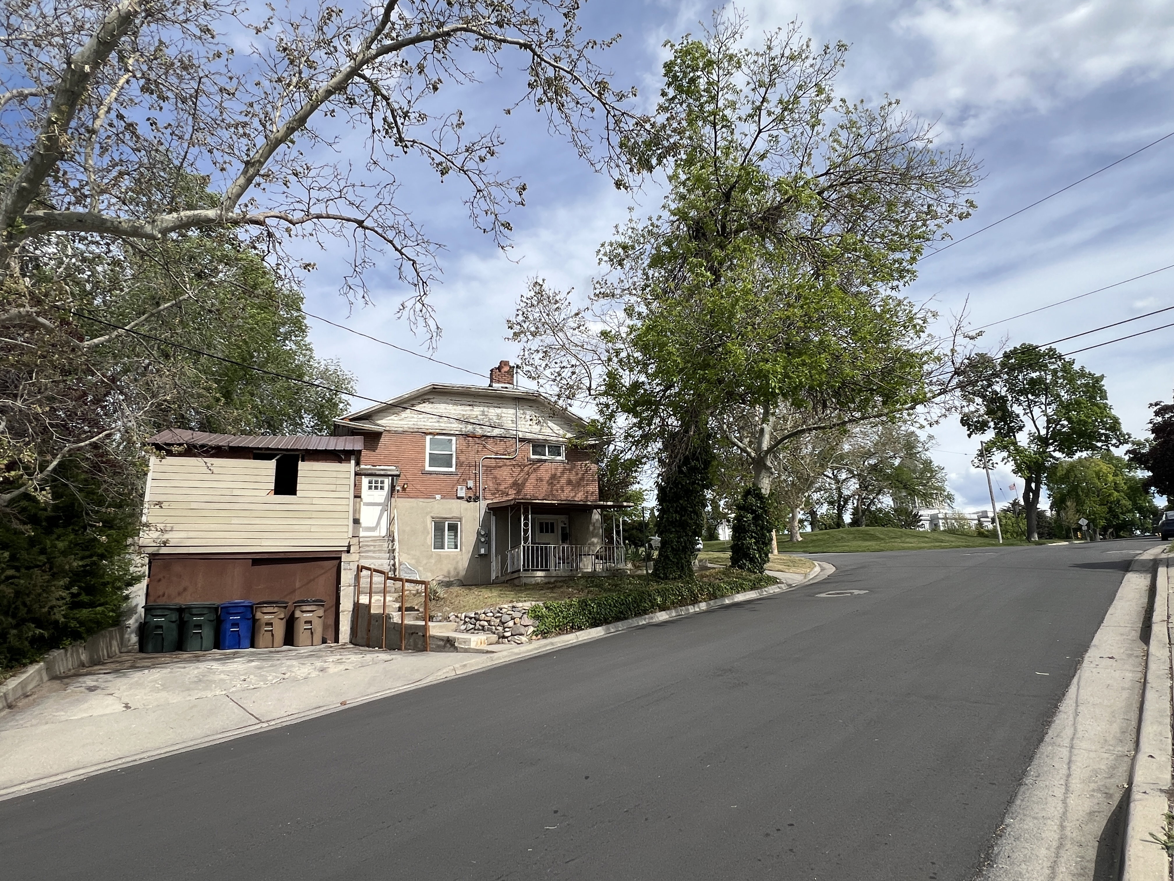 View of Capital, Garage, Driveway Parking, and Parking on asphalt road featuring curbs and sidewalks
