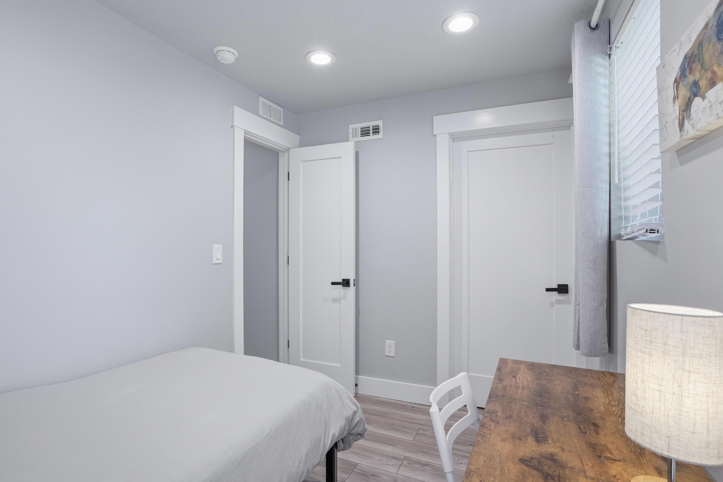 Furnished Unit #44 faces West. Bedroom with light wood-style flooring and recessed lighting
