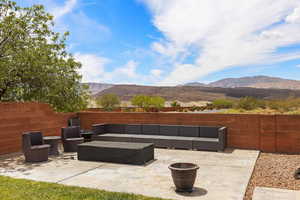 Fenced backyard featuring an outdoor lounge area, a patio, and a mountain view