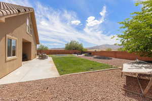 Fenced backyard featuring a mountain view and a patio