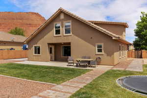 Rear view of property with a fenced backyard, stucco siding, a patio area, and a tile roof