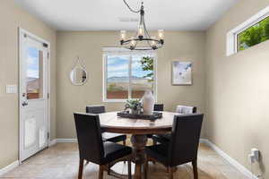 Dining room featuring a mountain view, light tile patterned floors, and a chandelier