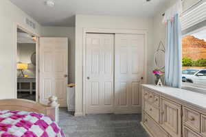 Bedroom featuring dark colored carpet and a closet