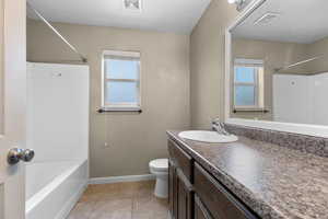 Bathroom featuring vanity, light tile patterned flooring, and washtub / shower combination