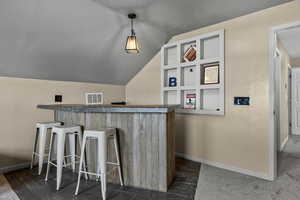 Indoor dry bar with vaulted ceiling and pendant lighting