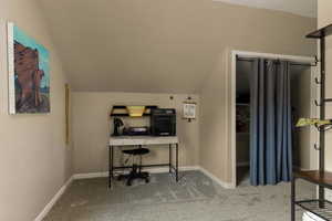 Office area with light carpet and vaulted ceiling
