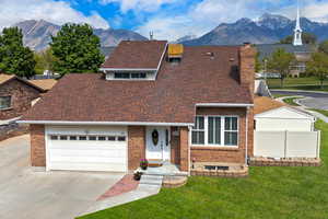 View of front of home with a mountain view, an attached garage. .**Pictures of yard are AI generated and reflect grass in yard. Seller is having a new sprinkler system installed and will reseed the yard at buyer's request**