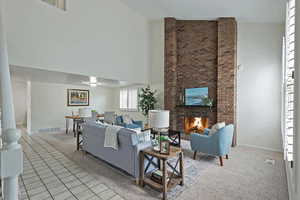 Living room featuring lofted ceiling, light tile patterned floors, and a brick fireplace
