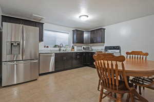 Basdment Kitchen featuring stainless steel appliances, dark wood finish cabinets,