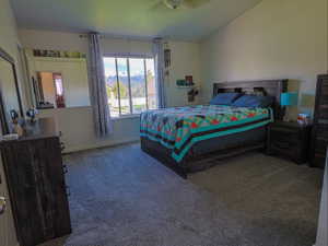 Bedroom with dark colored carpet, lofted ceiling, a mountain view, and a ceiling fan