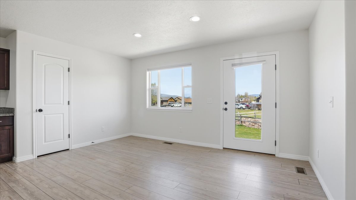 Unfurnished dining area with light wood-style floors and recessed lighting