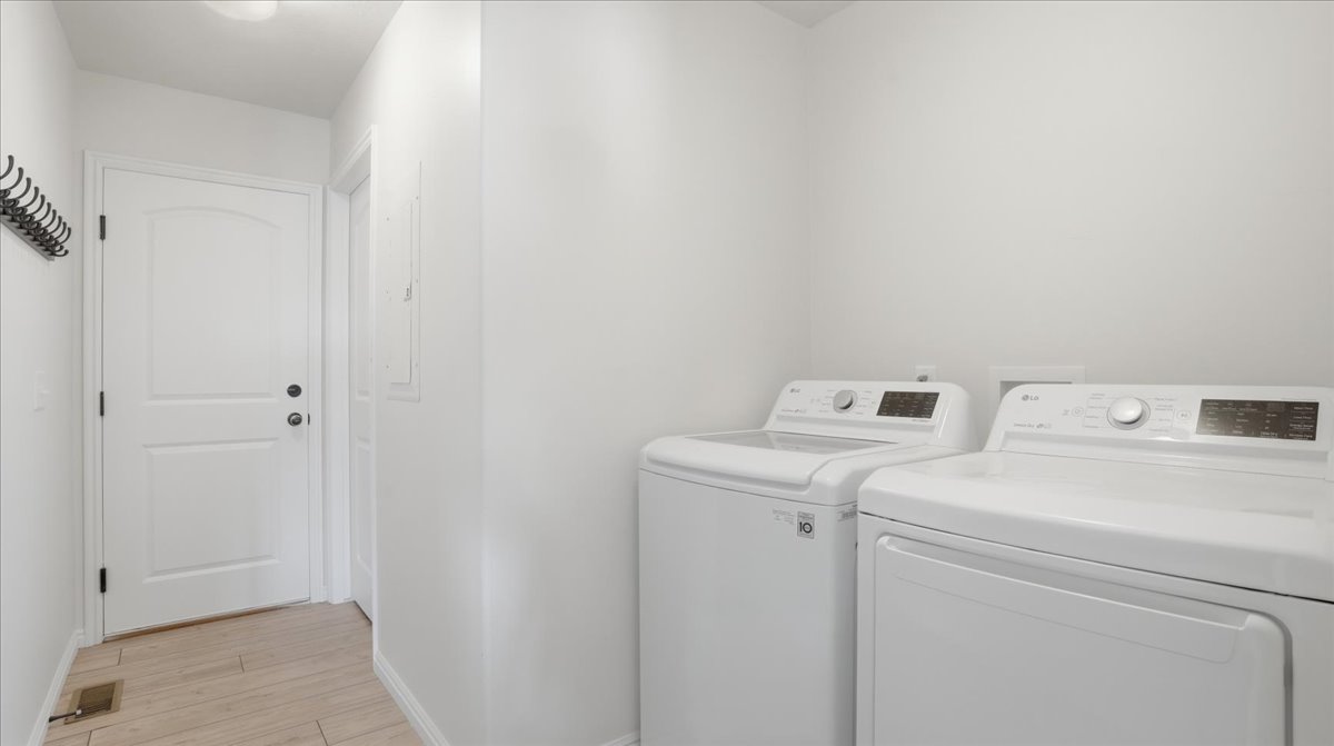Laundry area featuring washer and dryer and light wood-style floors