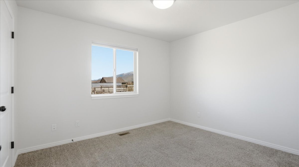 Empty room featuring baseboards and carpet flooring