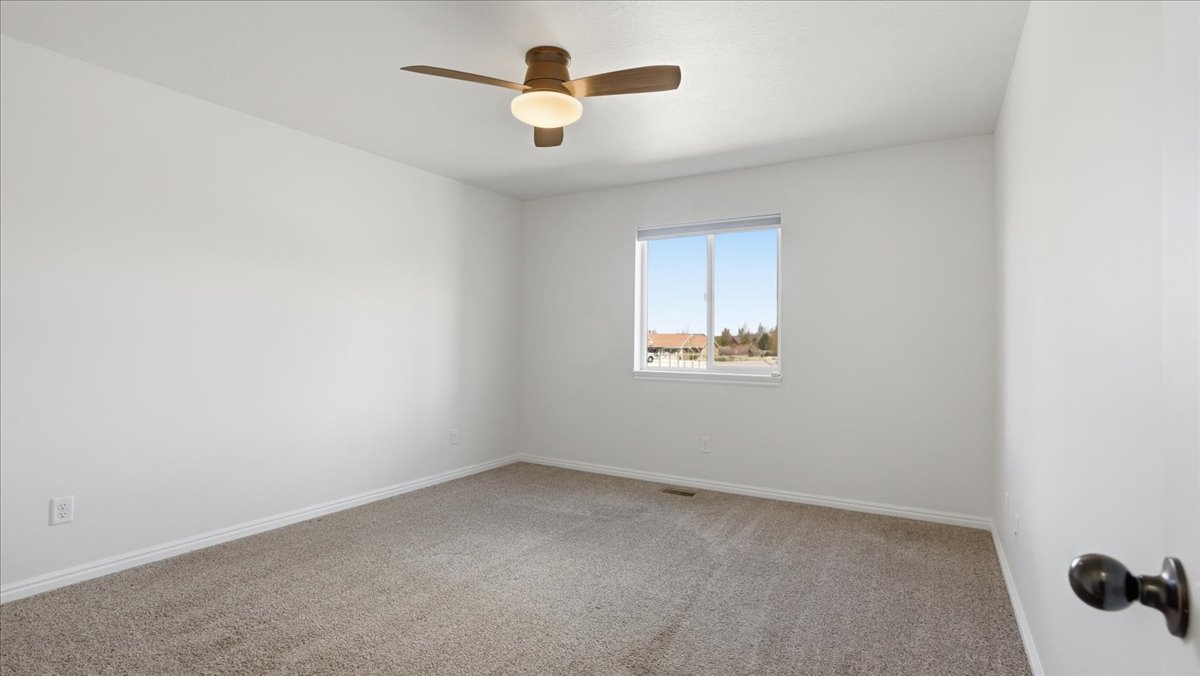 Spare room featuring carpet flooring and ceiling fan