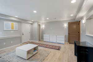 Living room with light wood finished floors and recessed lighting
