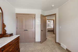 Bedroom featuring light carpet and a closet