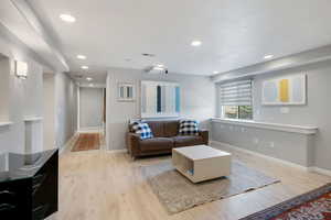 Living room featuring light wood-style flooring and recessed lighting