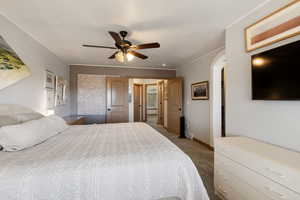 Bedroom with arched walkways, light carpet, and a ceiling fan