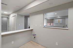 Bar area with light wood-style flooring and recessed lighting
