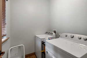 Laundry room with separate washer and dryer and baseboards