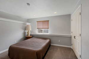 Bedroom featuring dark carpet, a closet, recessed lighting, and a textured ceiling
