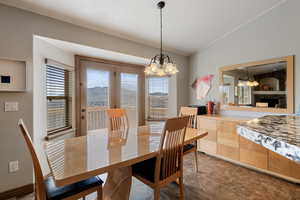 Dining area featuring a chandelier, a mountain view, healthy amount of natural light, and lofted ceiling