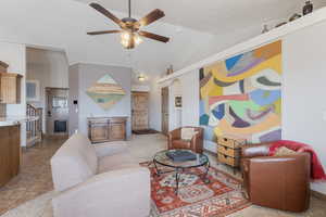 Living room featuring ceiling fan, vaulted ceiling, light tile patterned floors, and arched walkways