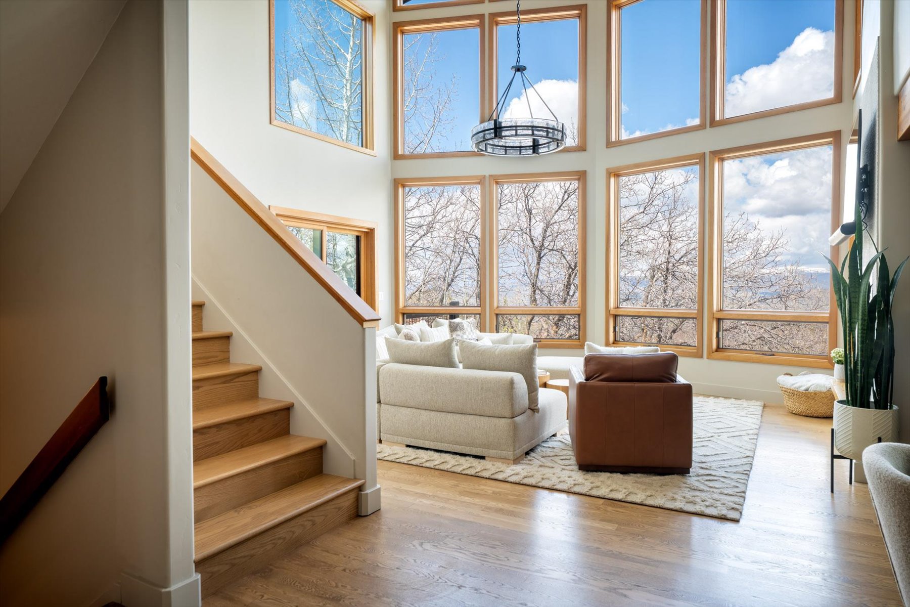 Living area featuring healthy amount of natural light, a high ceiling, and wood finished floors