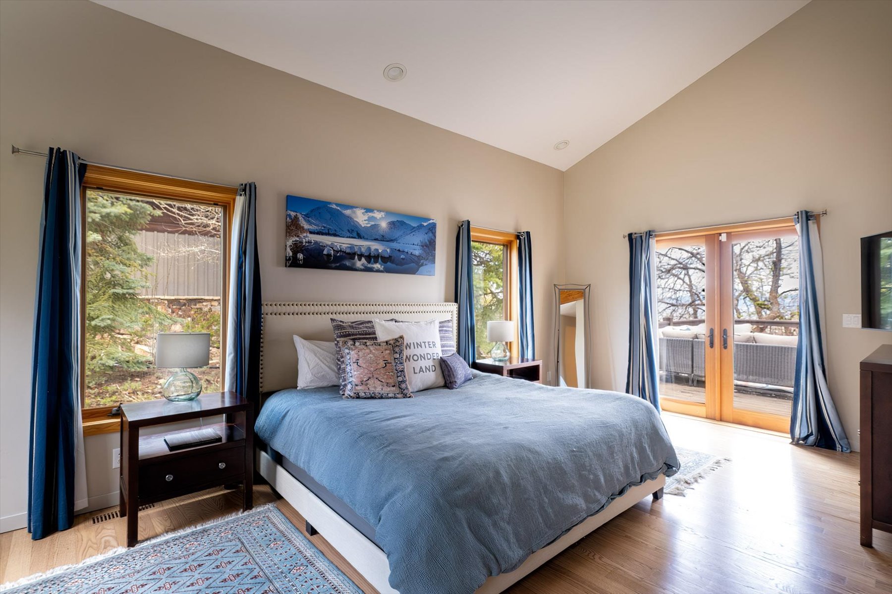 Bedroom featuring vaulted ceiling, light wood finished floors, french doors, and access to exterior