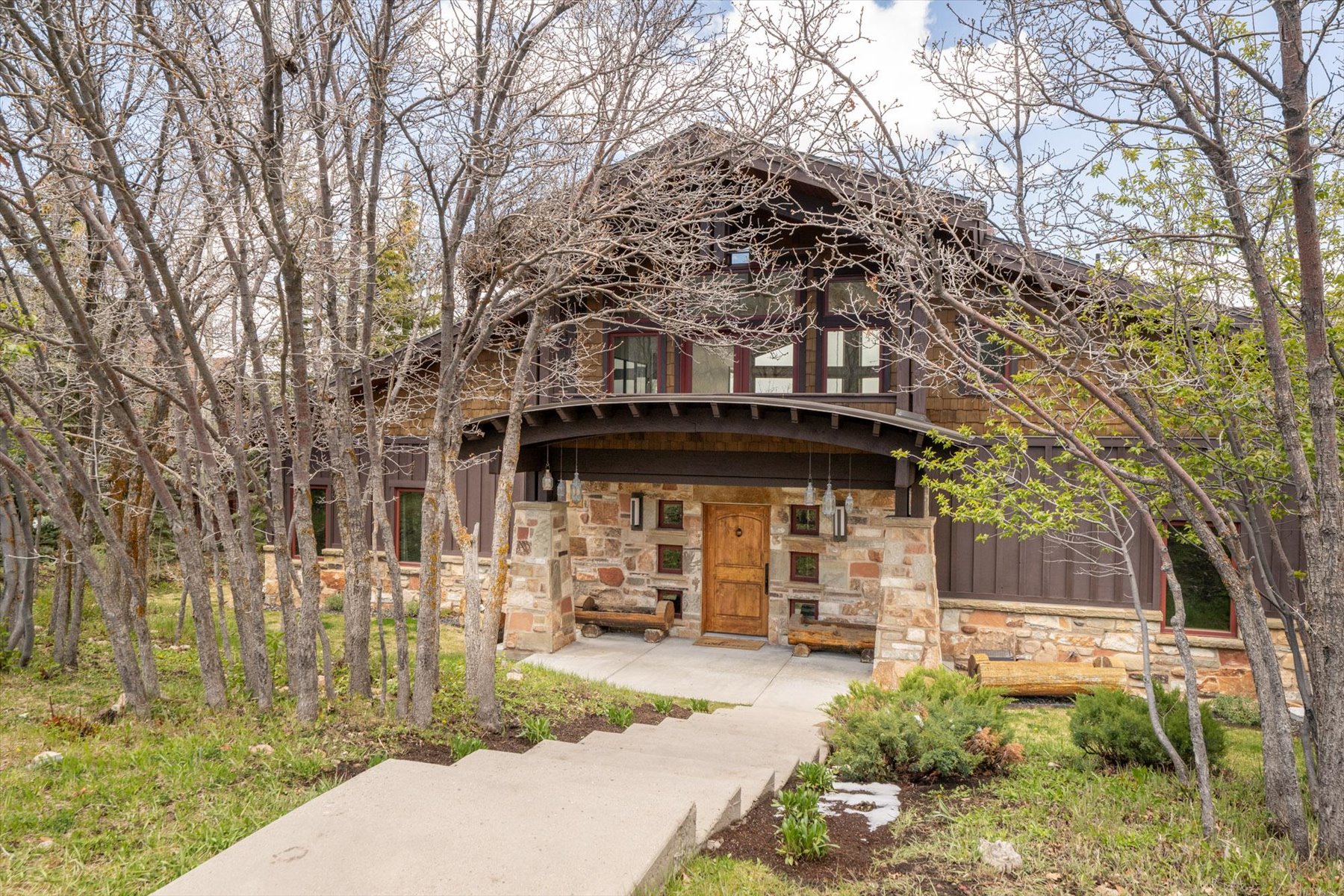 View of front of home featuring stone siding and covered porch