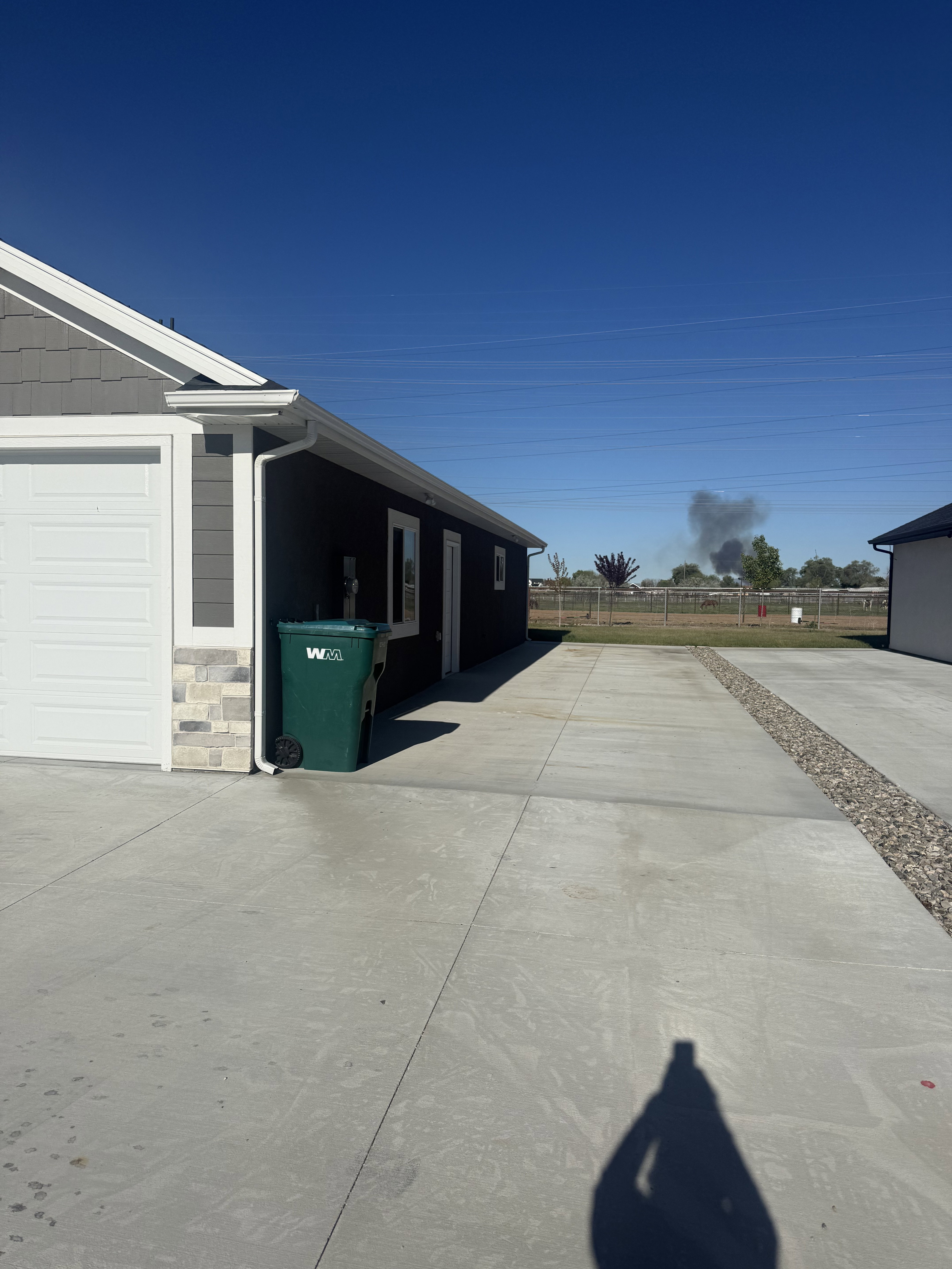 View of property exterior featuring stone siding and a garage