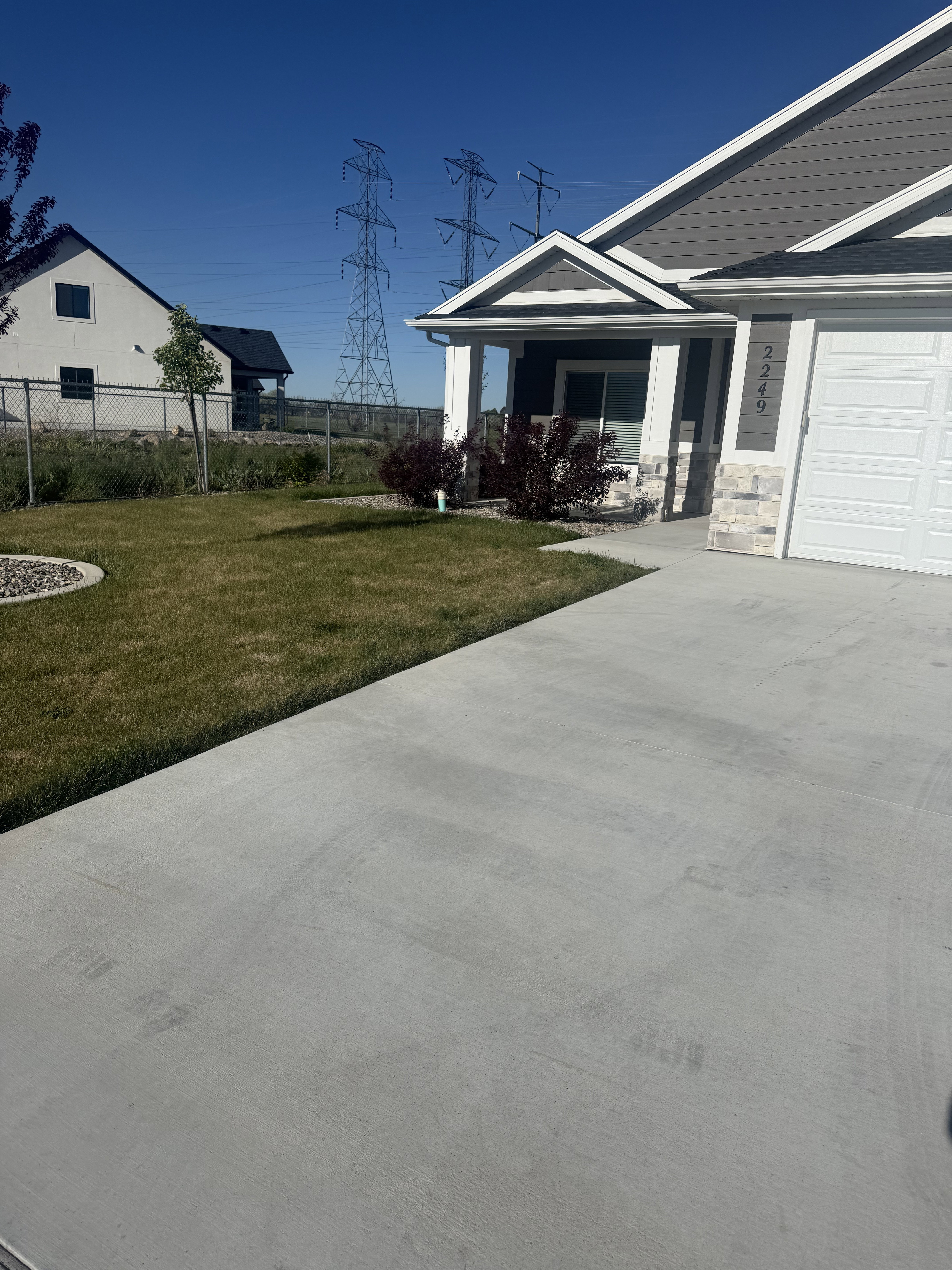 View of yard featuring covered porch, an attached garage, and concrete driveway