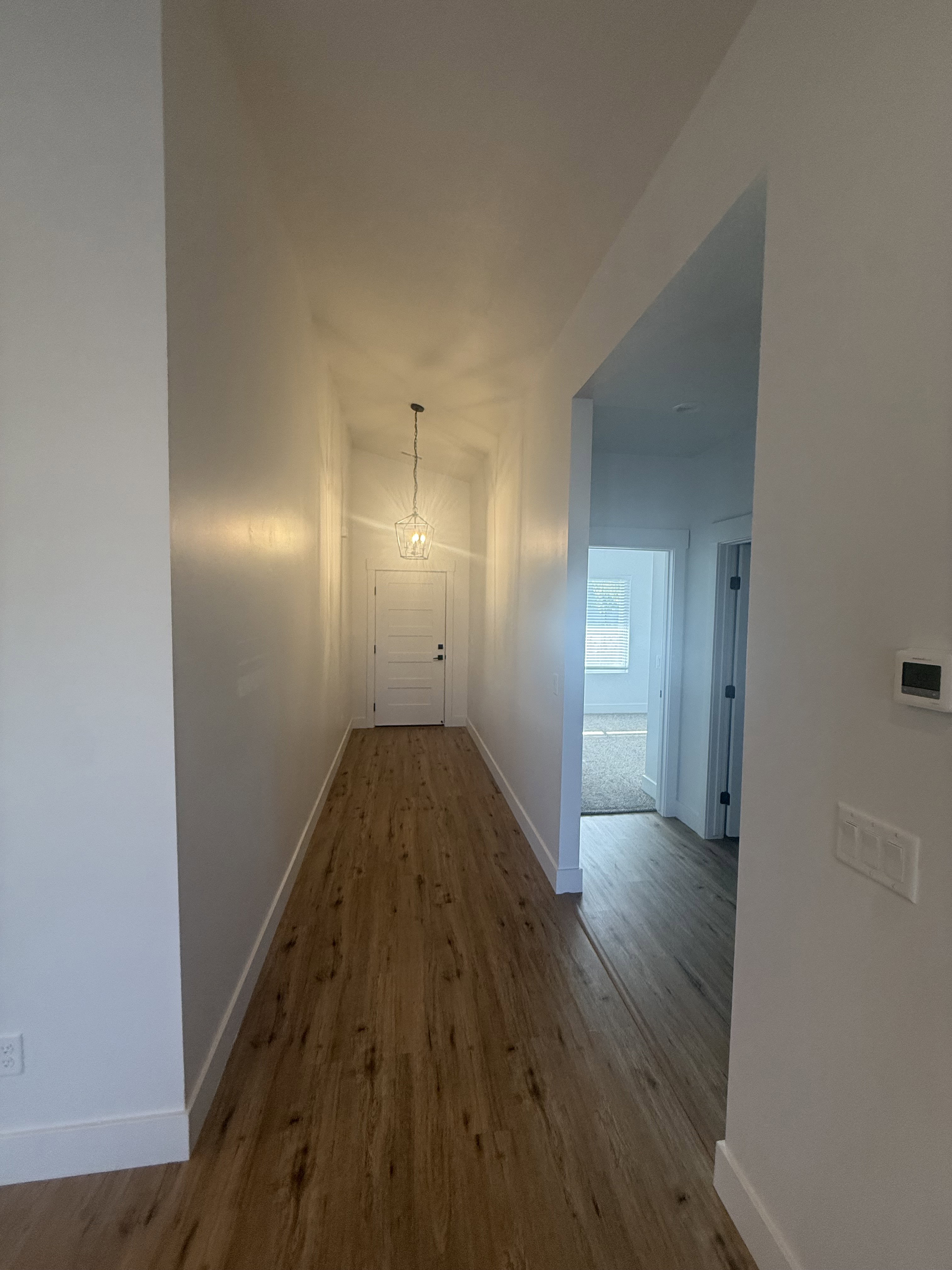 Hallway featuring wood finished floors and baseboards